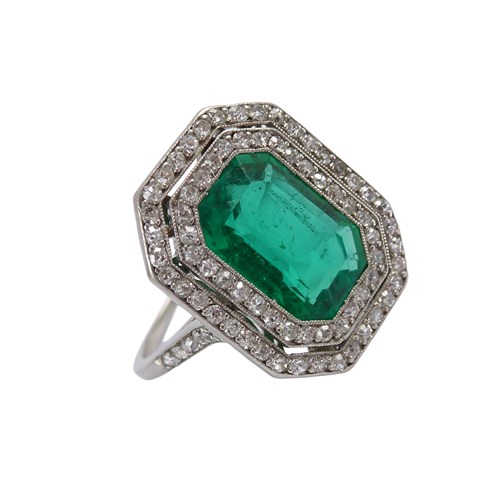 Early 20th century rectangular emerald and diamond cluster ring, French c.1915, centred by cut corner rectangular emerald of step cut, approximately 2.70ct,